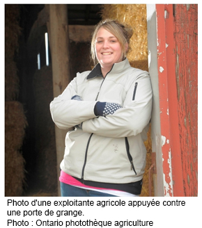 Photo d'une exploitante agricole appuyée contre une porte de grange.
Photo : Ontario photothèque agriculture