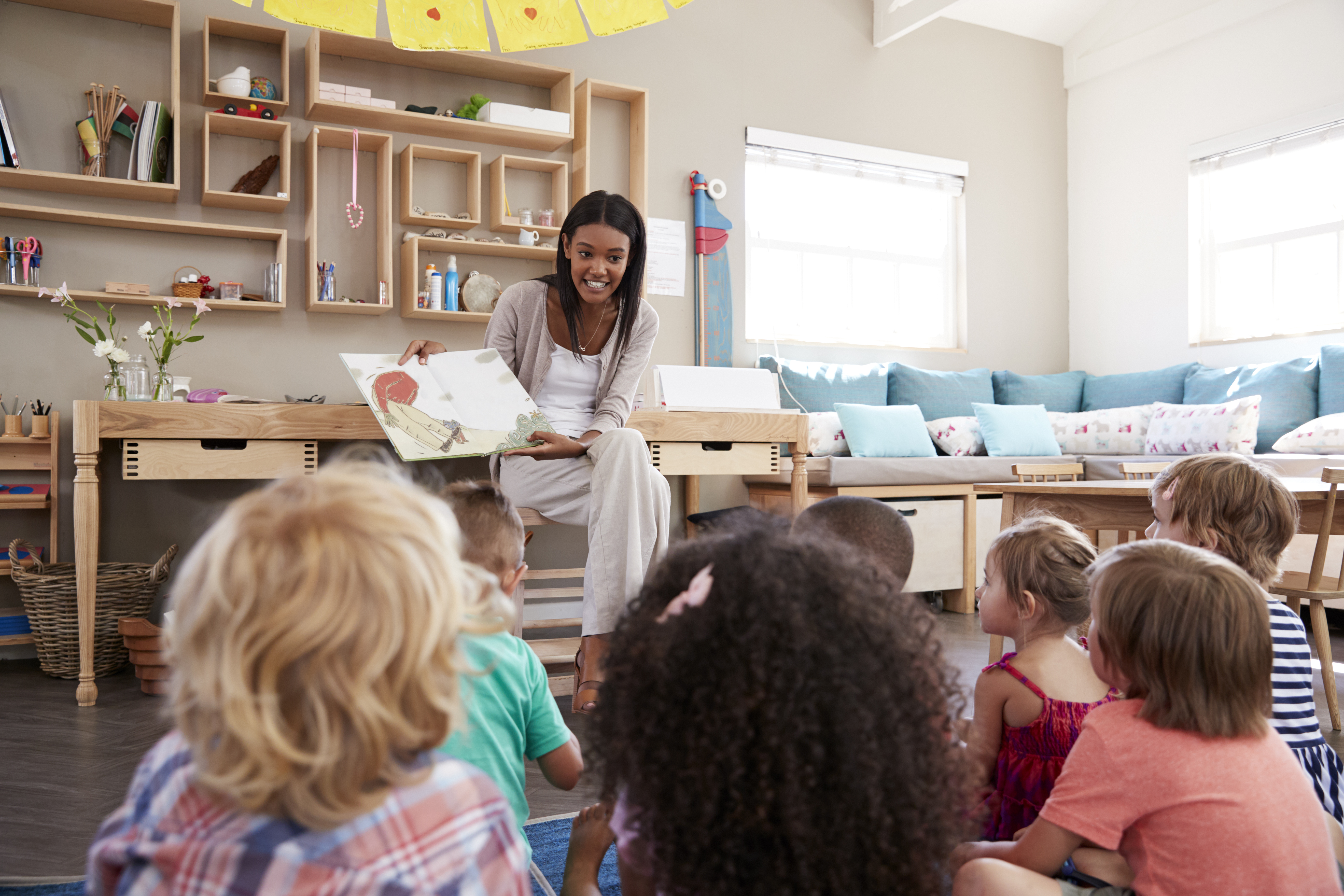 Enseignante qui fait la lecture aux enfants dans une classe