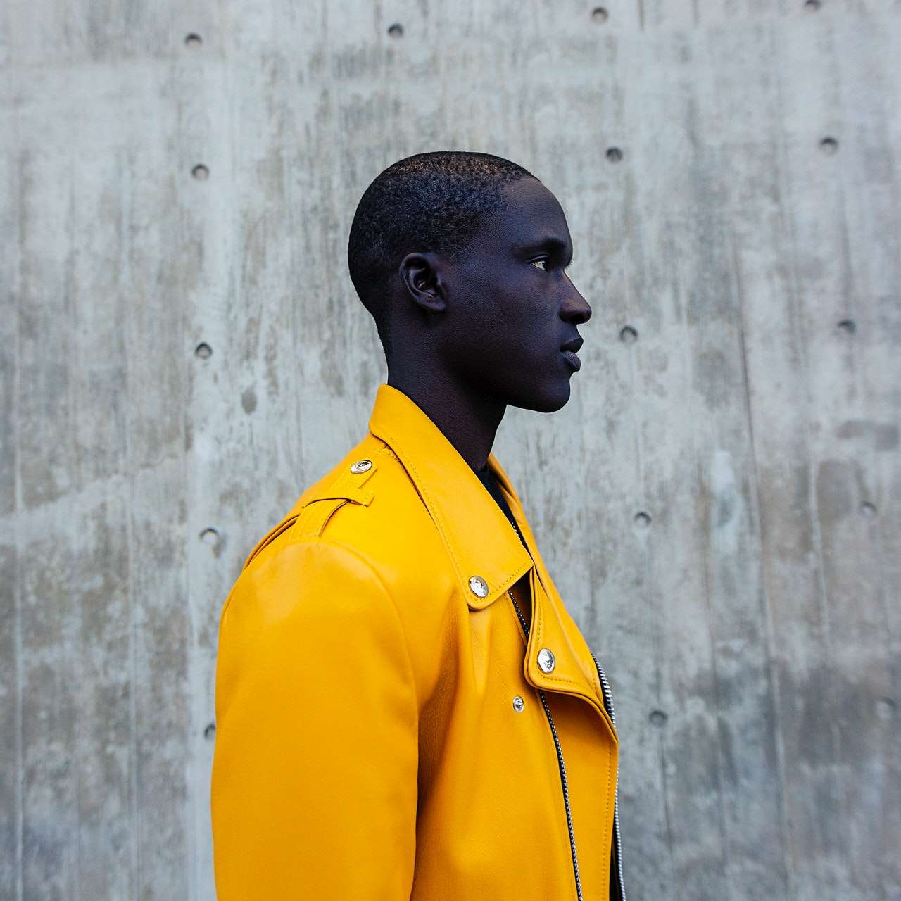 Profil latéral d'un homme portant une veste jaune vif.