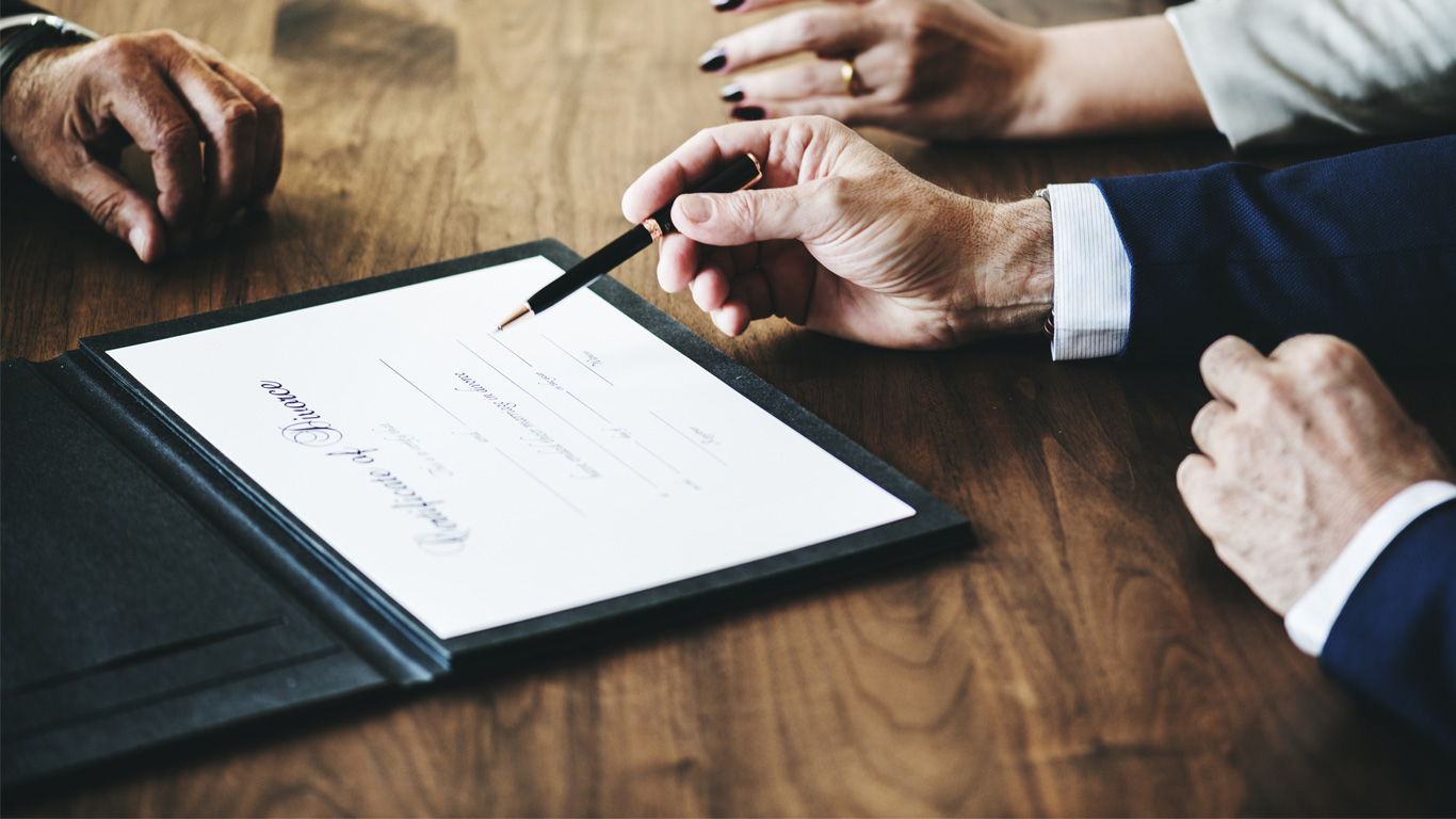 Three people sitting at a table reviewing documents.