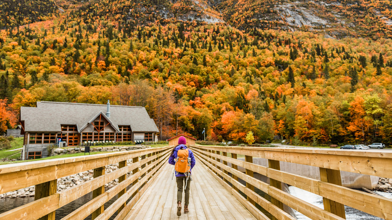 A woman walking across a wooden bridge in rural Quebec.