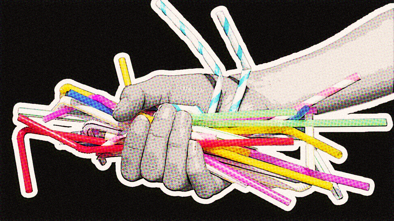 A hand holding plastic drinking straws.