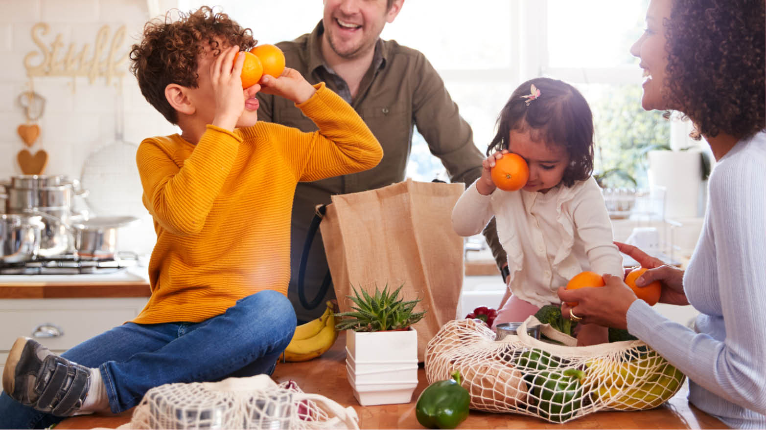 Au retour de l’épicerie, une famille sort les produits des sacs réutilisables sans plastique dans leur cuisine.