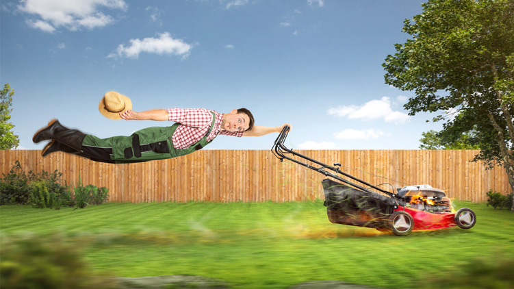 Image amusante d'un jardinier tiré sur la pelouse par une puissante tondeuse à gazon.