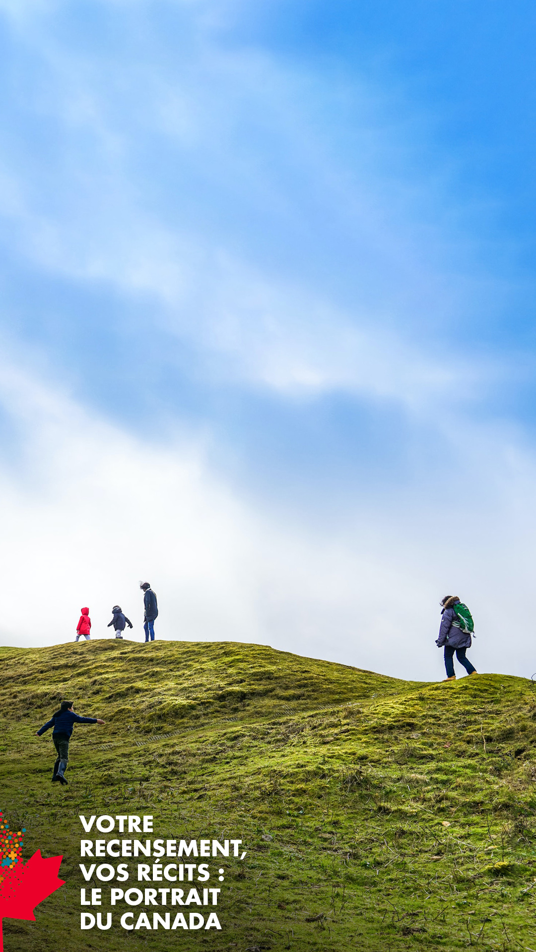 Votre recensement, vos récits : Le portrait du Canada - Une famille de cinq personnes marchant sur une colline couverte d'herbe sous un ciel bleu