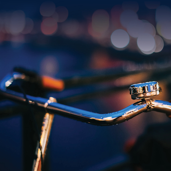 Gros plan sur un guidon de vélo avec une ville en arrière-plan. 